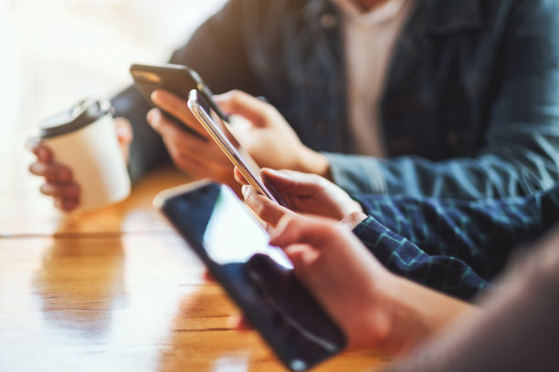 人们坐在一起使用和看手机图片下载