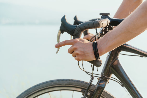 男性双手握着刹车方向盘。图片下载