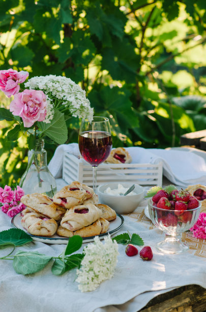 桌上放着甜面包和草莓。大自然中的乡村风格照片。图片下载