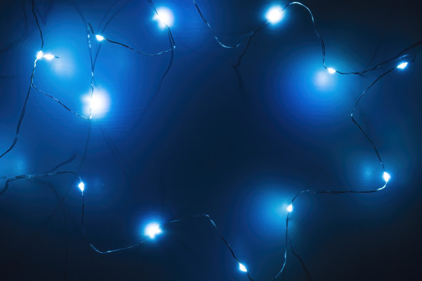 顶视图的木背景上的花环在黑暗。蓝色灯光的圣诞背景，拷贝空间。图片下载