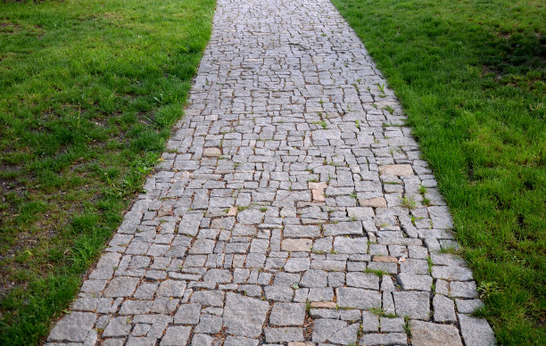 花岗岩铺砌不规则分段的碎石路，公园周围有绿色草坪灰色的人行步道图片下载