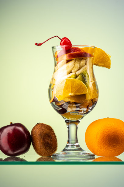 水果沙拉的新鲜水果和浆果在一个透明的玻璃梯度背景图片下载