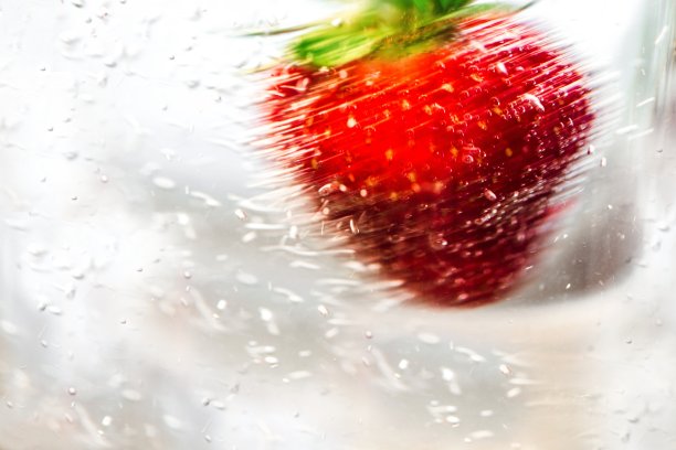 草莓在旋转的水中。图片下载