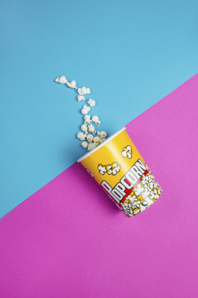 蓝色和紫色背景上的黄色爆米花盒图片下载