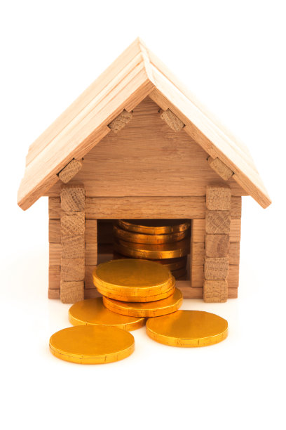 带有金币的木制玩具房子孤立在白色的背景上。图片下载