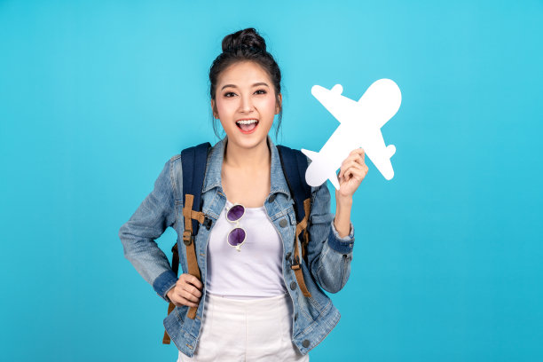 年轻的亚洲青少年背包女孩的概念准备出国旅行与白纸飞机在手和积极的微笑相机。适合新冠肺炎后的飞行服务和旅行计划。图片下载