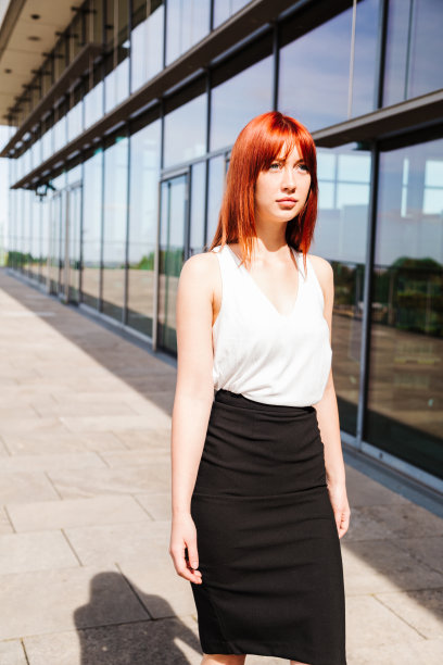 年轻的商业女性走过现代建筑图片下载