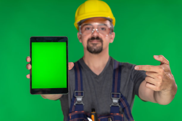 建筑工人显示数字平板与色度键绿色屏幕图片下载