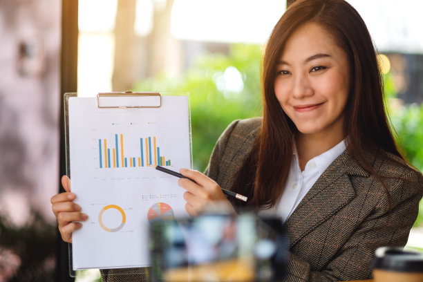 一个美丽的年轻亚洲女人用笔记本电脑在网上教授商业课程图片下载