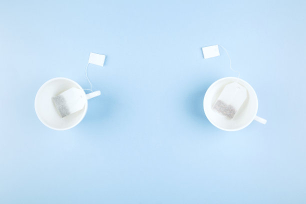 蓝色背景上的茶杯和茶包。俯视图，复制空间。食品的背景图片下载