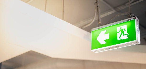 当建筑物或公共区域发生火灾时，悬挂在建筑物内的大型绿色消防出口灯显示逃生路线。图片下载