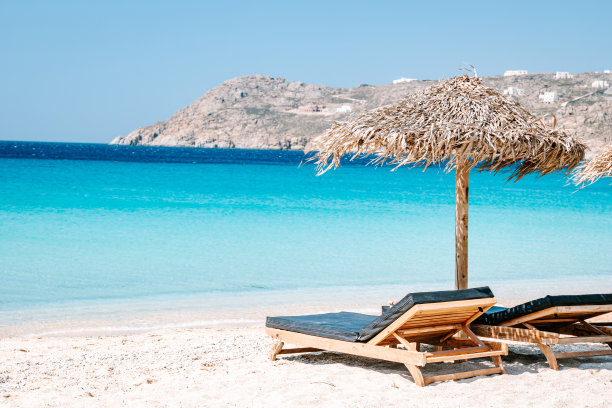 希腊米科诺斯海滩上带伞的热带沙滩椅图片下载