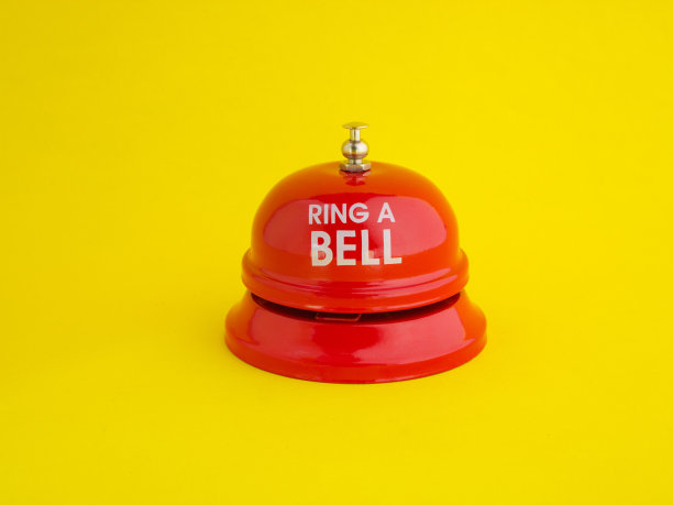 红色的桌面铃在明亮的黄色背景上放置了“铃”的信息。图片下载