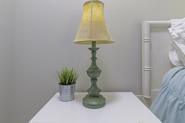 床边的床头柜上放灯和植物图片下载