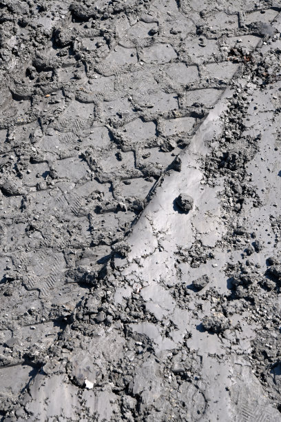 泥土里有车辆轮胎的痕迹。有趣的泥浆背景。泥泞的土壤质地。图片下载