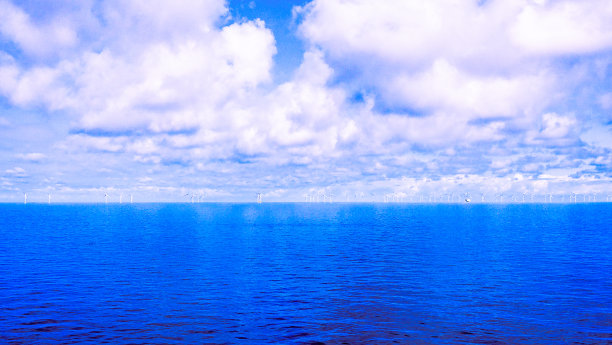 皇家蓝色的海景和风力涡轮机在地平线上图片下载