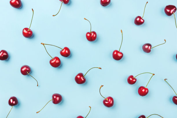 蓝色背景上成熟樱桃的明亮图案。图片下载