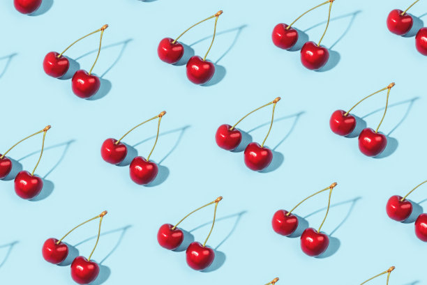 蓝色背景上成熟樱桃的明亮图案。图片下载