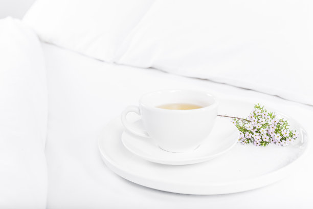 床上放着白色的茶杯和鲜花图片下载