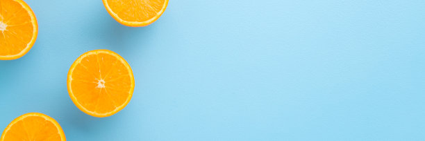 鲜亮的半块橙子。宽横幅美丽的新鲜水果。浅蓝色表格背景上的空白位置。柔和的颜色。特写镜头。自顶向下的观点。图片下载