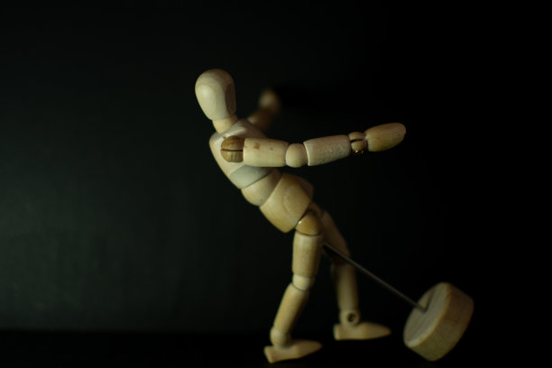 木制人体模型倒在黑色背景上图片下载