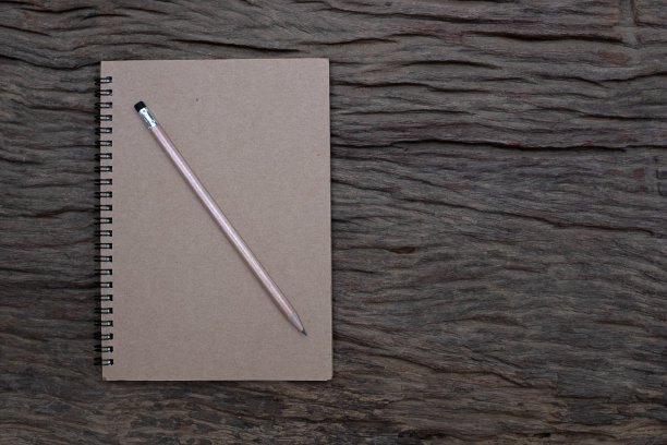 背景是旧木桌上的书本模型上面的铅笔，平躺照片，俯视图图片下载