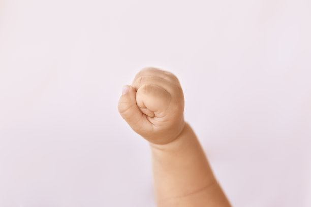 刚出生的女婴拳头在自然光线柔和的背景图片下载