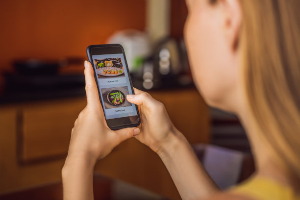 一名年轻女子用智能手机在网上订午餐图片下载