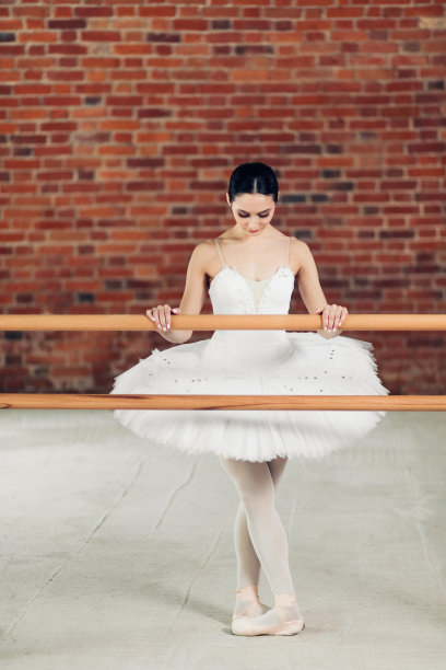 完整的照片。穿着白色连衣裙的女子在表演芭蕾舞姿势图片下载