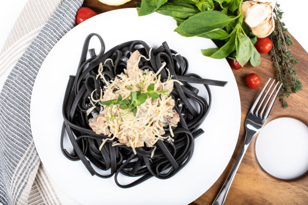 黑色干面条(用墨鱼汁做成的意大利面)，配上帕尔玛芝士和火腿酱汁图片下载
