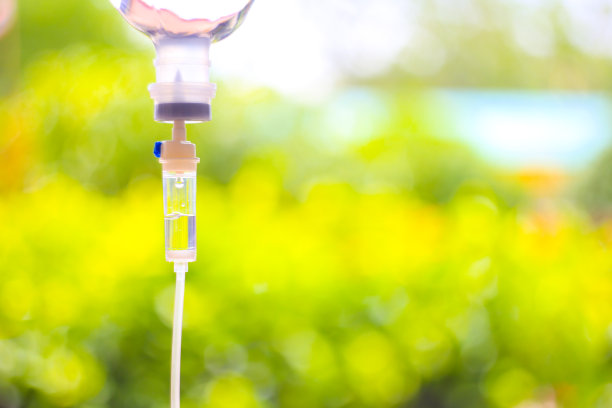 设静脉输液，静脉滴注生理盐水，医院病房点滴，医疗理念，治疗急诊，注射药物输液，护理化疗，理念。蓝光背景，选择性聚焦库存照片图片下载