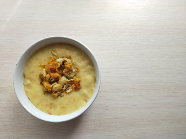 白盘子里的牛肉胡萝卜泥汤，背景很淡。图片下载