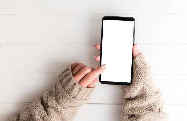 俯视图的女孩在毛衣使用智能手机图片下载