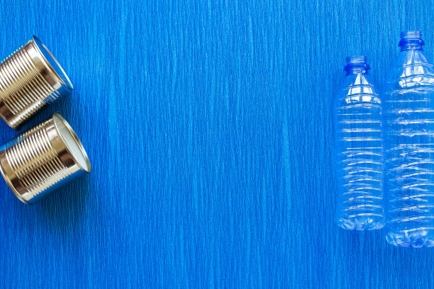 回收利用。材料可回收再利用塑料瓶、蓝底锡罐。前视图。平躺图片下载