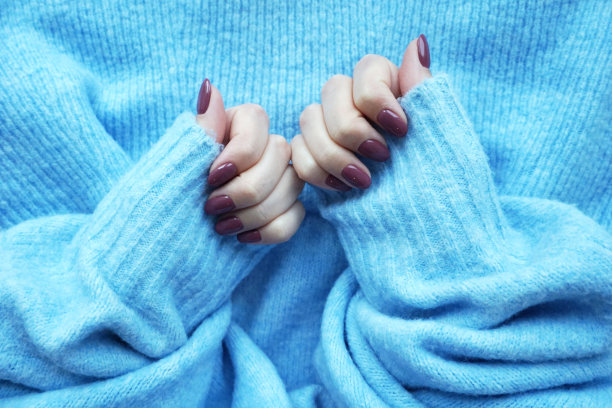紫色的指甲和蓝色的毛衣。图片下载