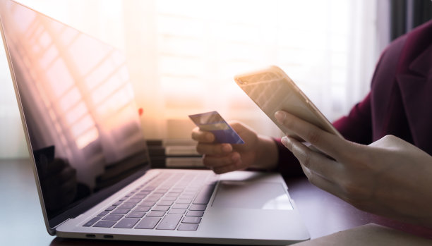 手持信用卡，使用智能手机与笔记本电脑购买网上购物素材图片