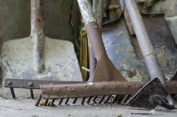 地面上各种生锈的园艺工具的特写。图片下载