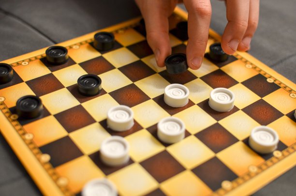 孩子手玩跳棋棋盘游戏。黑色和白色。图片下载