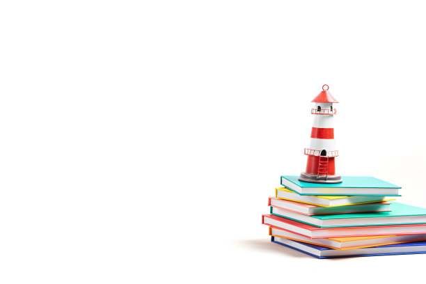 灯塔屹立在那堆书上。国际扫盲日，书籍冒险，想象和旅行图片下载