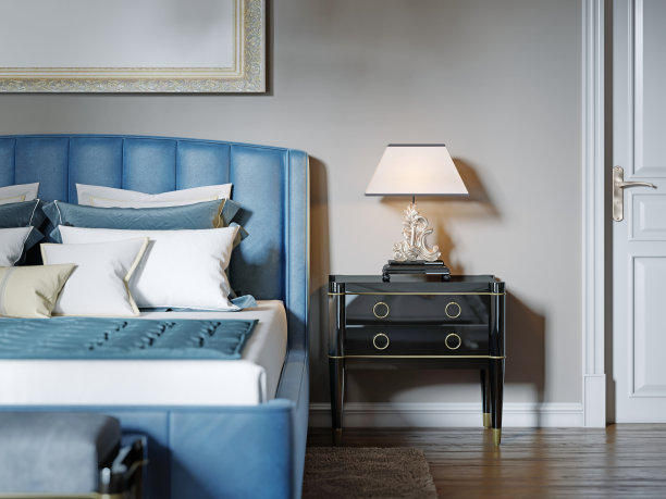 黑漆床头柜，配有台灯和银色卷曲的支架。这个灯罩是方形的。图片下载