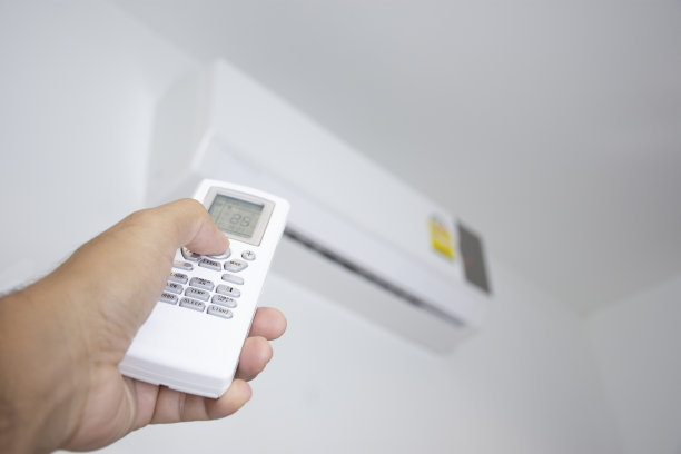人的手正在使用空调的白色遥控器图片下载