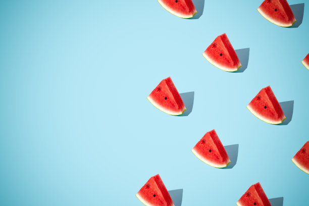 最小的平铺食物质地。夏日抽象新潮清新的概念。红色西瓜切片图案在明亮的浅蓝色背景上，复制空间图片下载
