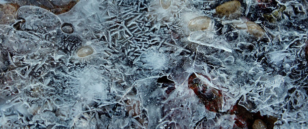 冬天，河里的石头上结了薄薄的裂冰图片下载