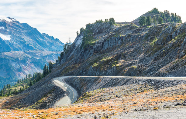在夏季的一天，山上的曲线和斜坡沥青路的风景。图片下载