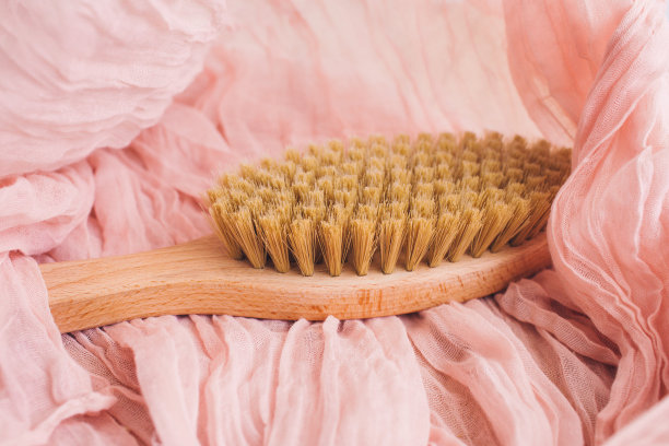 木制刷在粉红色背景干按摩。侘寂的美学。天然材料。图片下载