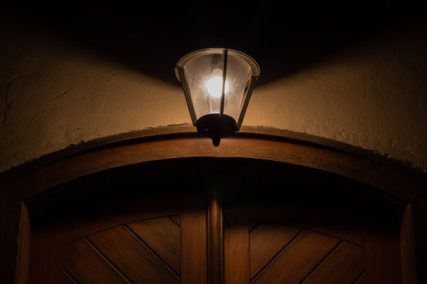 晚上木门上挂着一盏古老的灯图片下载