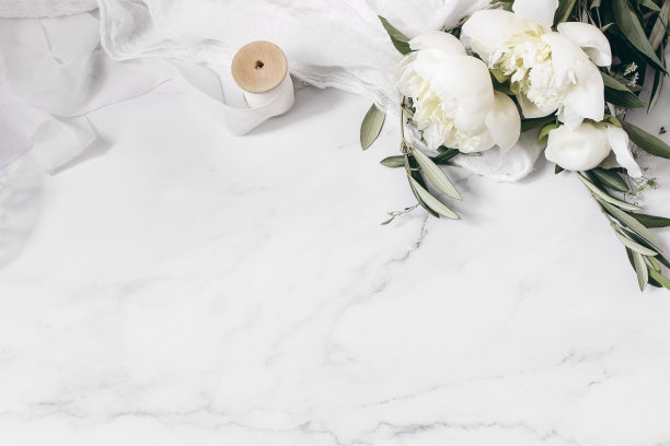 婚礼花卉静物构图。大理石桌上摆一束白色牡丹花、橄榄枝，配以绸布和丝带。复古女性照片，平躺，俯视图，没有人。空的空间图片下载