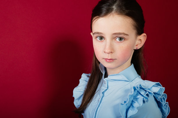 红色背景上的一个女学生的肖像，她站在茁壮成长，向前看图片下载