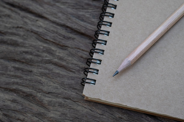 背景是旧木桌上的书本模型上面的铅笔，平躺照片，俯视图图片下载