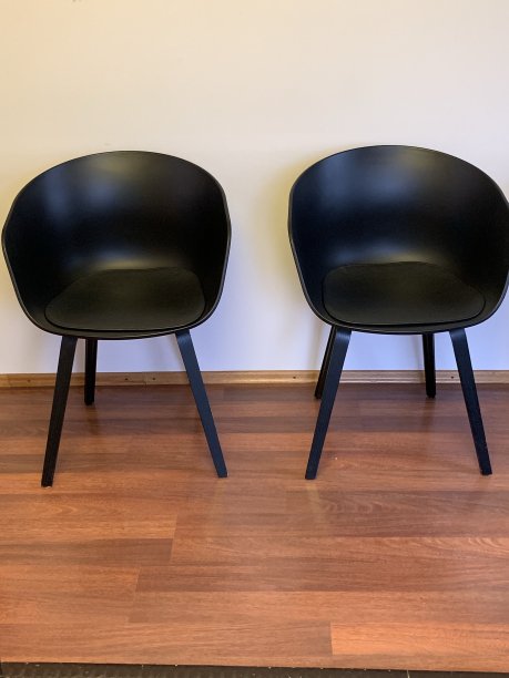 木地板上放着两把黑色的现代椅子图片下载